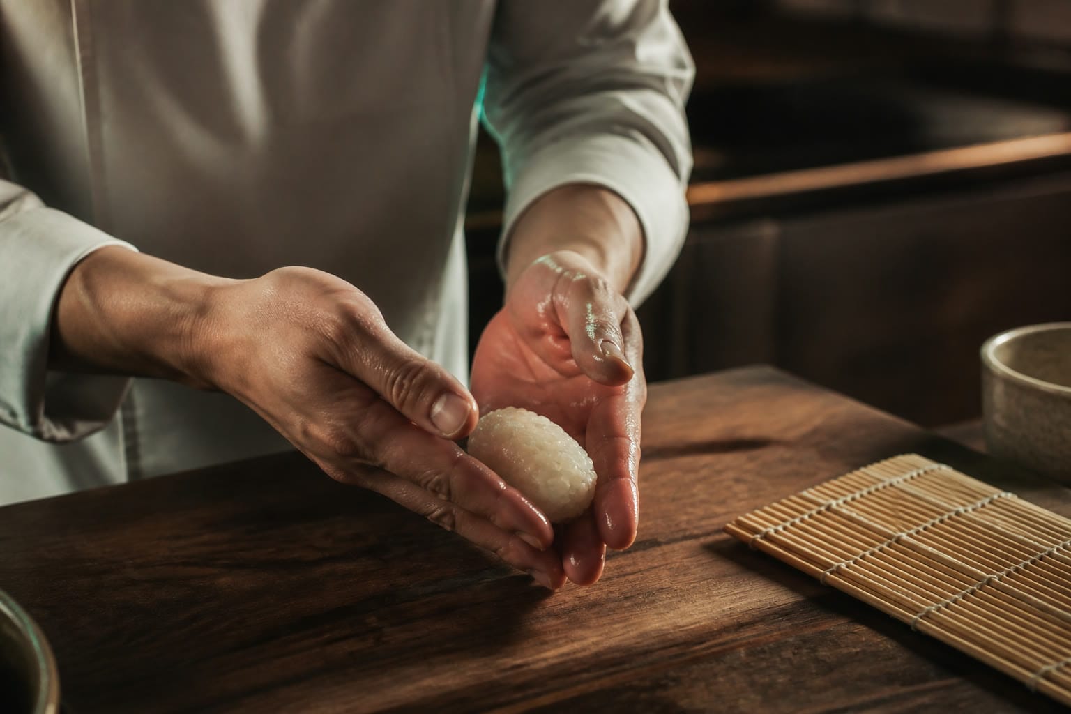 Rice is seasoned, cooled, and shaped by hand.